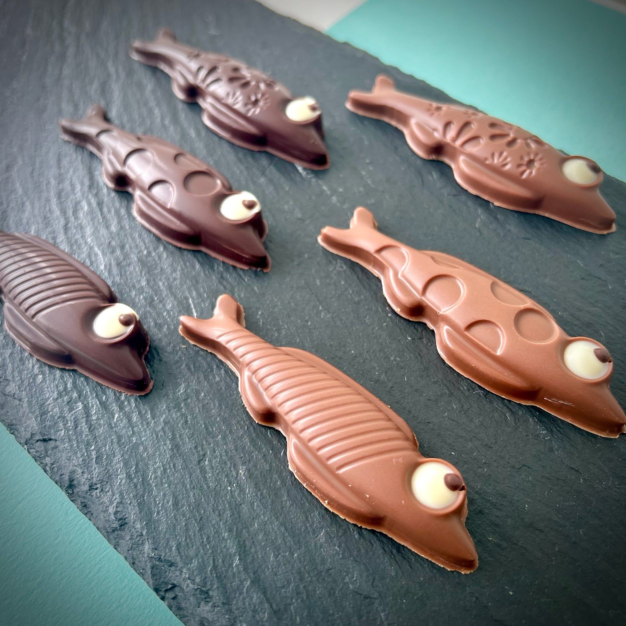 Gros plan sur les détails ludiques des sardines en chocolat au lait et chocolat noir de M. & Mme Chocolat, un chocolatier artisanal basé à Montréal, Petite Patrie. Livraison disponible partout au Québec.