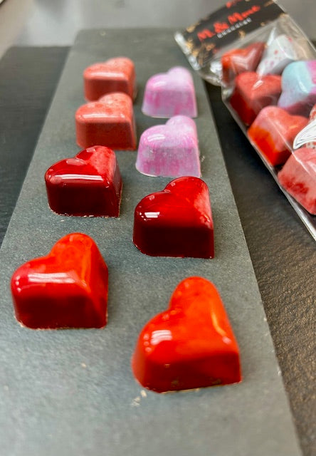 Sachets de cœurs en chocolat noir et lait garnis de praliné maison amande/noisette. Chocolats artisanaux faits à la main à Montréal pour un cadeau de Saint-Valentin de qualité