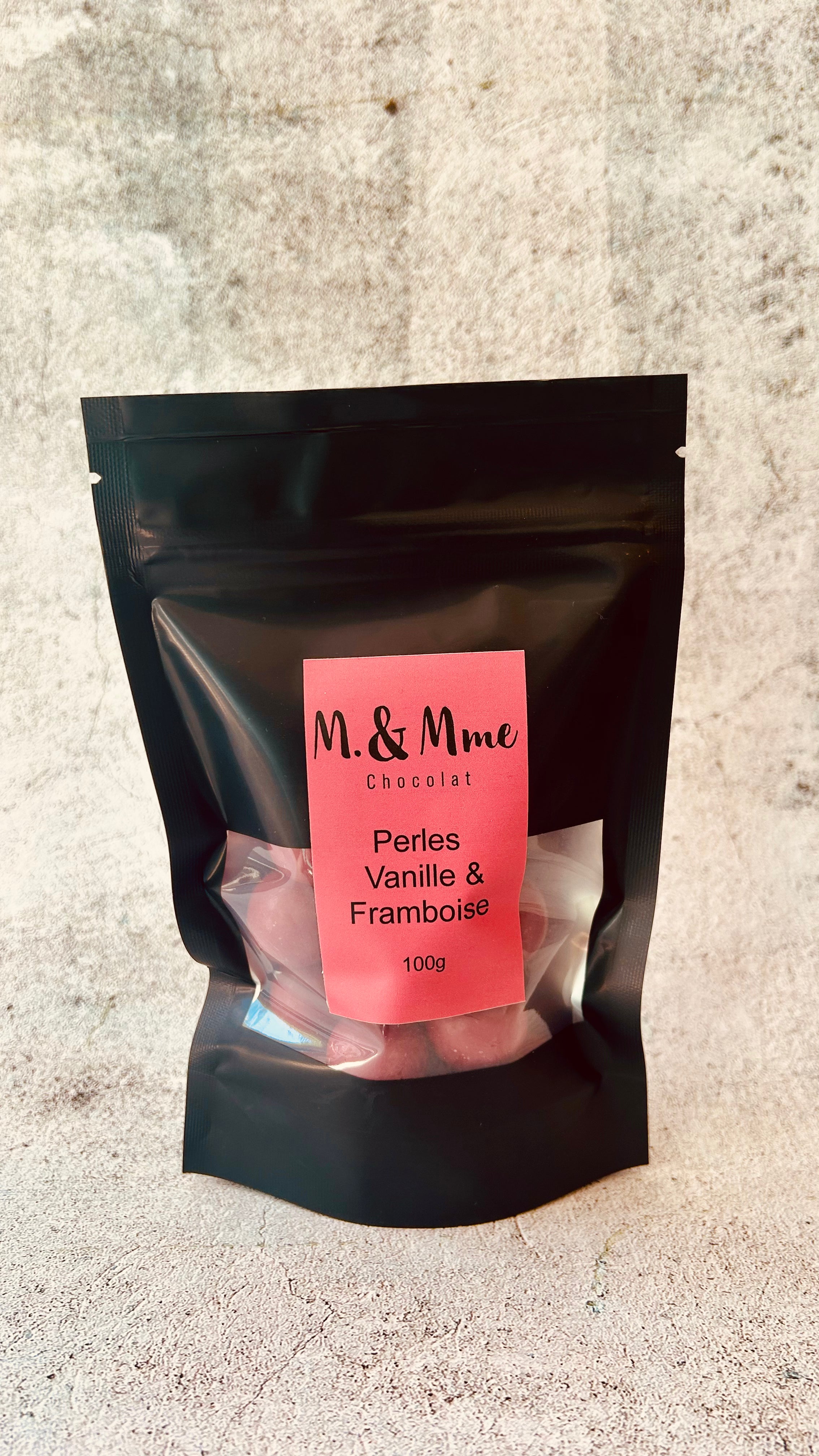 Bouchées, Perles de chocolat blanc, vanille et riz soufflé, enrobées du chocolat Inspiration Framboise de Valrhona. Une de nos créations favorites!