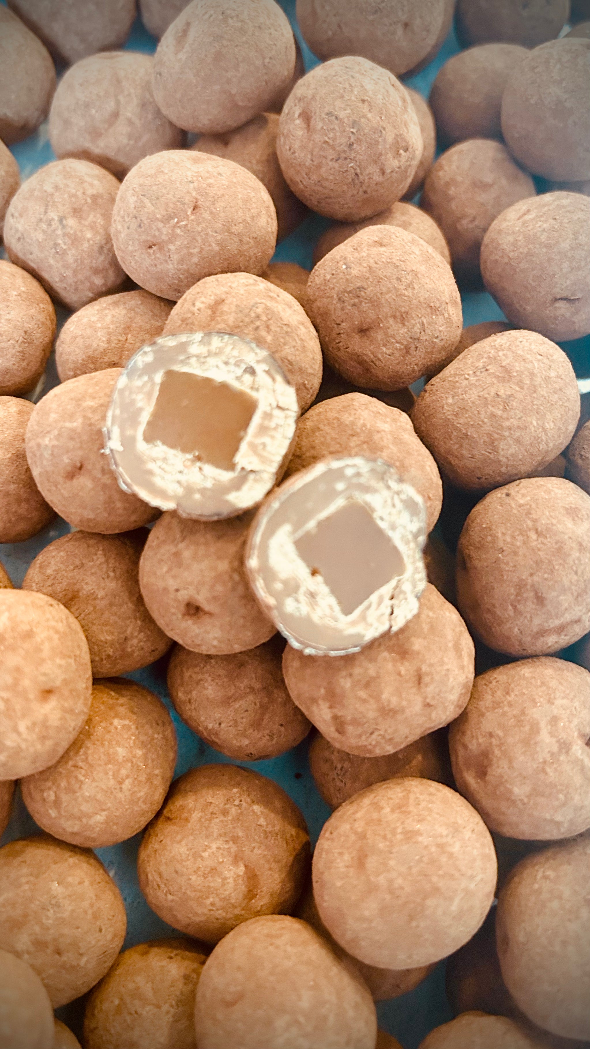 Bouchées de caramel tendre enrobé de chocolat au lait caramélisé et légèrement saupoudré de poudre de cacao.
