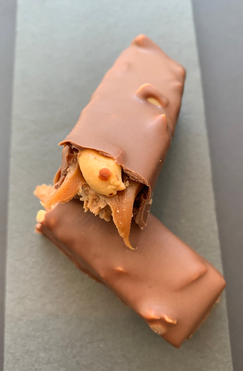 Barre de Chocolat, caramel tendre, arachides salées et rôties, praliné aux arachides pimenté, enrobé de chocolat au lait 