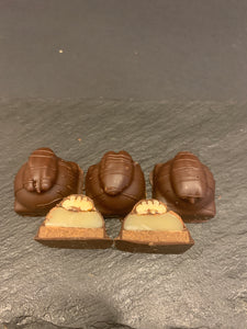 Bouchées tortues, enrobées de chocolat noir ou lait, faites de caramel tendre, praliné à la pacane rôtie et pacane entière sur le dessus.